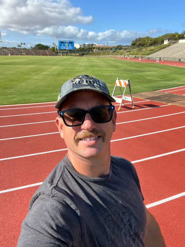Paul taking a selfie at a running track